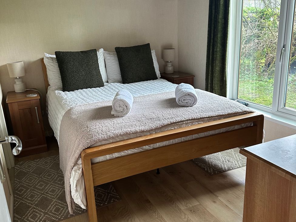 A bedroom with a bed and bedside table at Tiggywinkle Beck - White Cross Bay Windermere