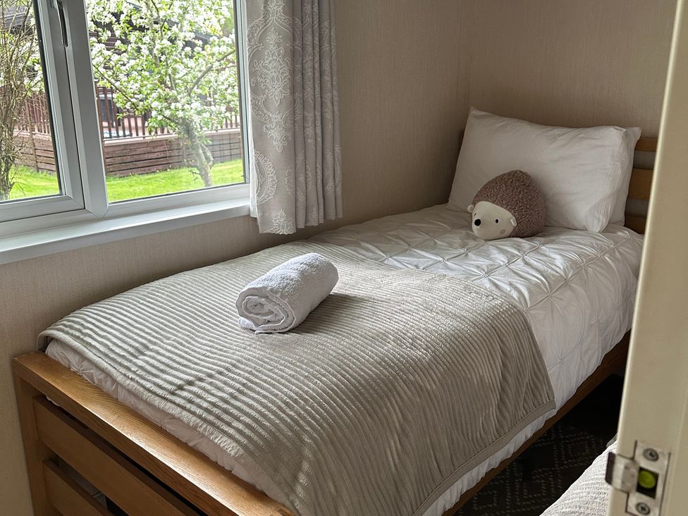 A single bed with a pillow and towel in a bedroom at Tiggywinkle Beck - White Cross Bay Windermere