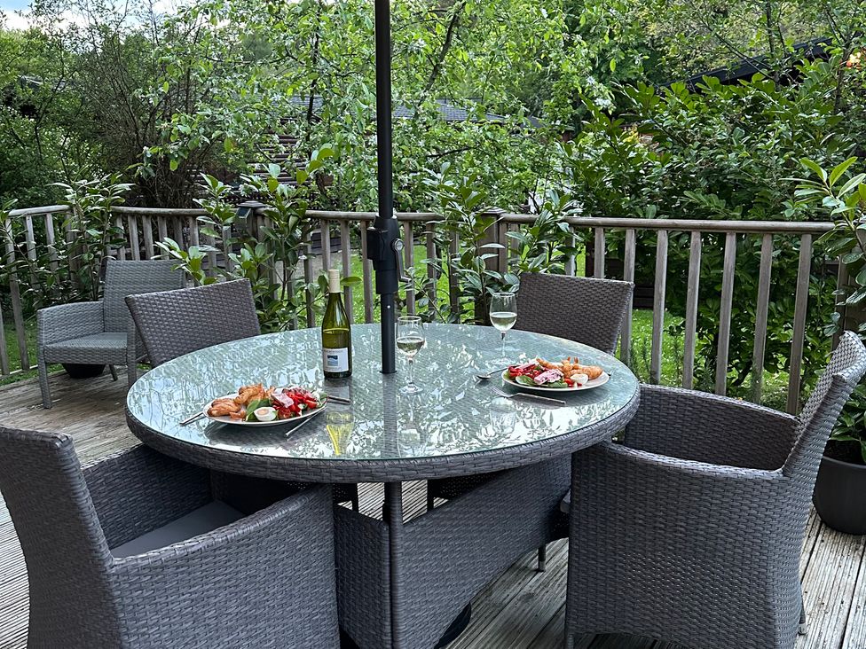 An outdoor dining area with a table and chairs at Tiggywinkle Beck - White Cross Bay Windermere