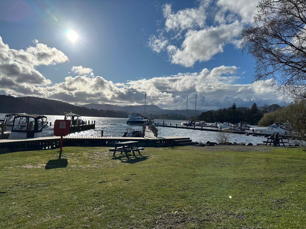A view of boats at a pier with a picnic table and water at Tiggywinkle Beck - White Cross Bay Windermere