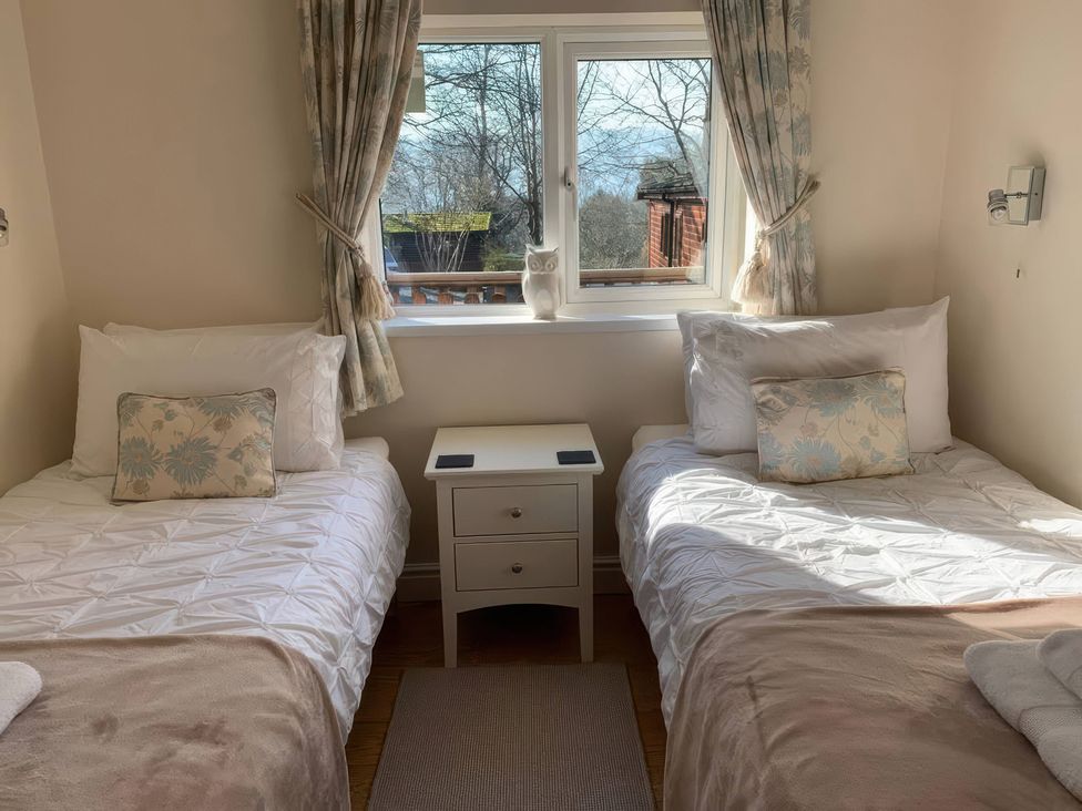 A bedroom with two beds and a window at Owls House - White Cross Bay in Windermere