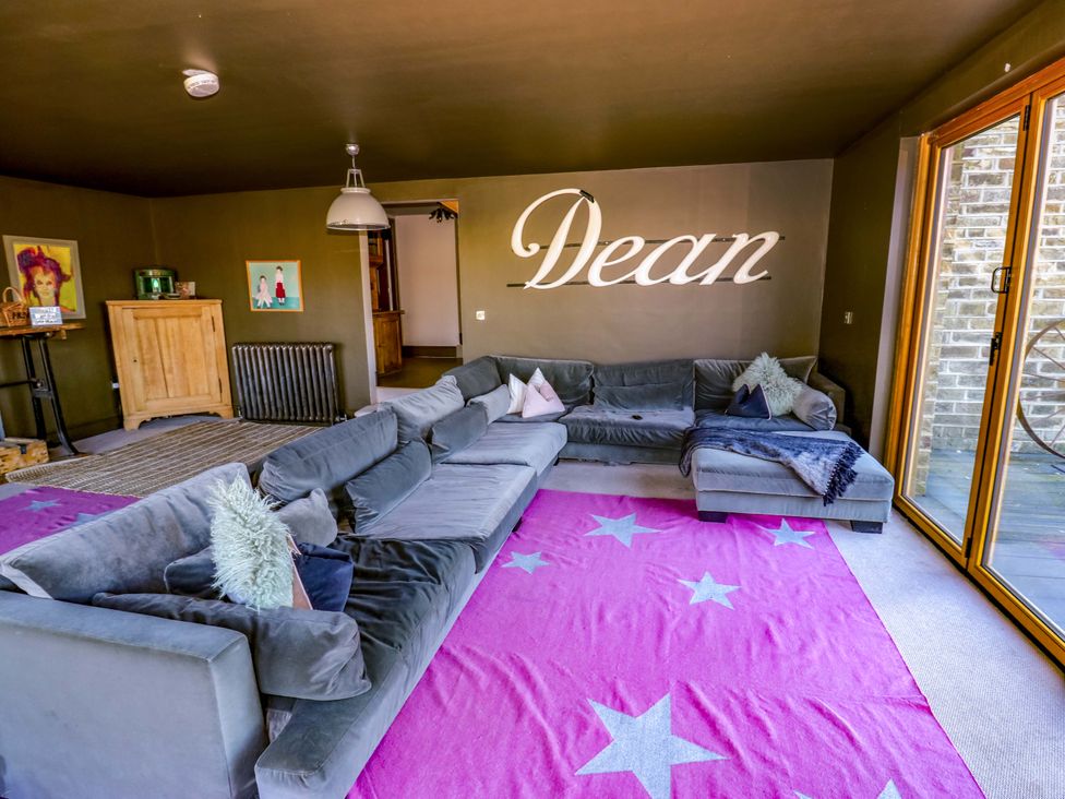 A living room with a large sofa and art on the walls at Rocks Cottage in Halifax