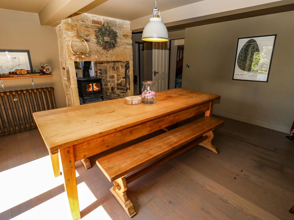 A dining room with a wooden table and benches at Rocks Cottage Halifax