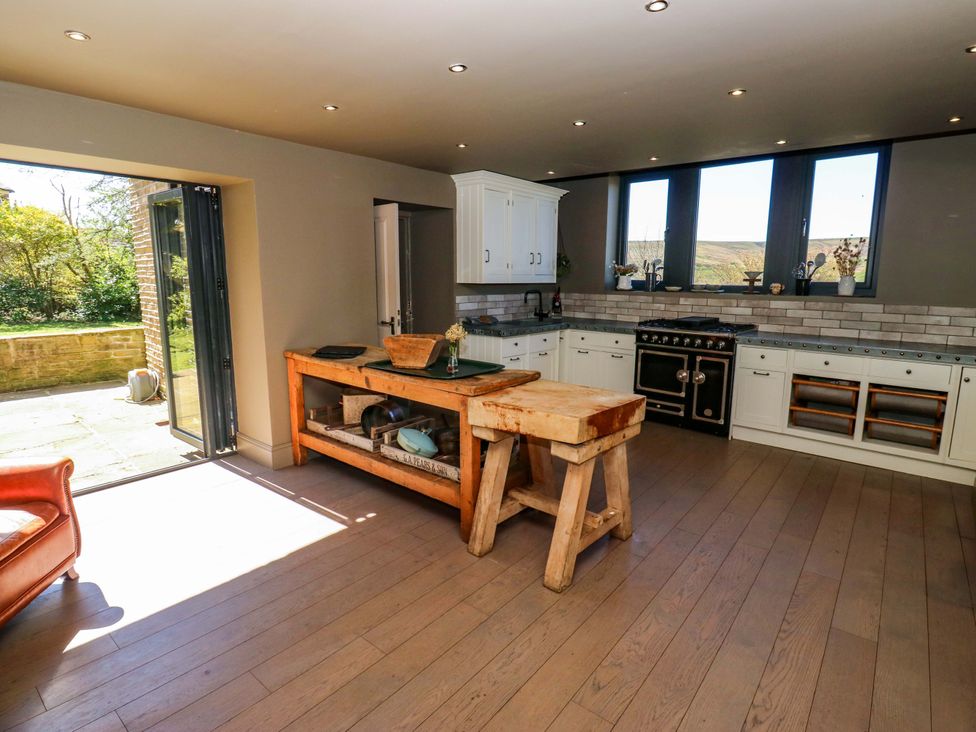 A kitchen with a stove and table at Rocks Cottage in Halifax