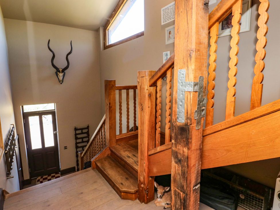 A staircase with wood railing and an antler mounted on the wall at Rocks Cottage Halifax