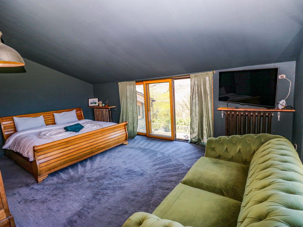 A bedroom with a bed and couch at Rocks Cottage in Halifax