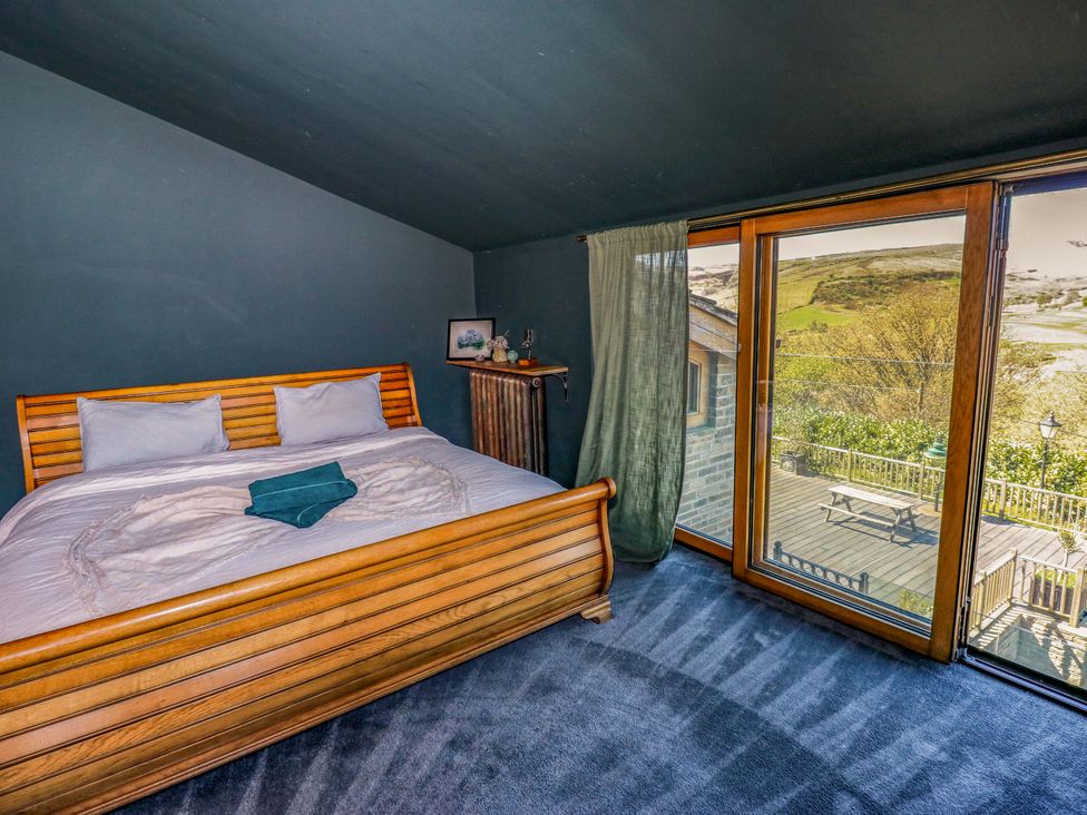 A bedroom with a bed and large window at Rocks Cottage Halifax