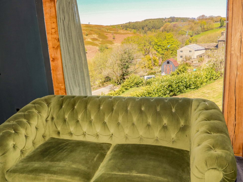 A couch with a view of trees and buildings at Rocks Cottage in Halifax