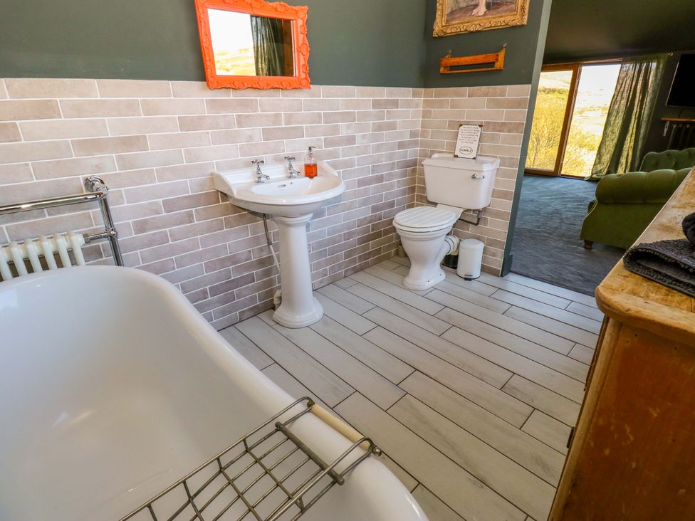 A bathroom with a bathtub, sink, and toilet at Rocks Cottage Halifax