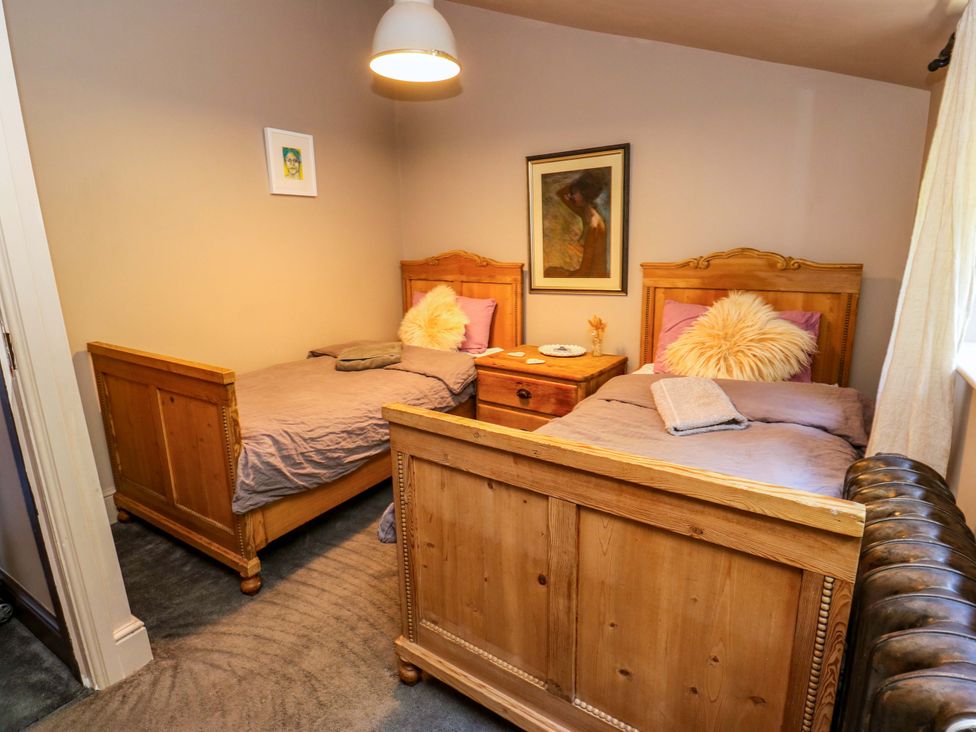A bedroom with two wooden beds and a nightstand at Rocks Cottage Halifax