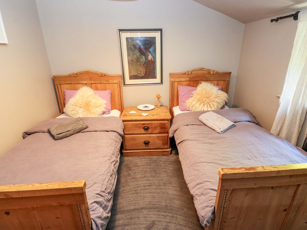 A bedroom with two beds and a bedside table at Rocks Cottage in Halifax