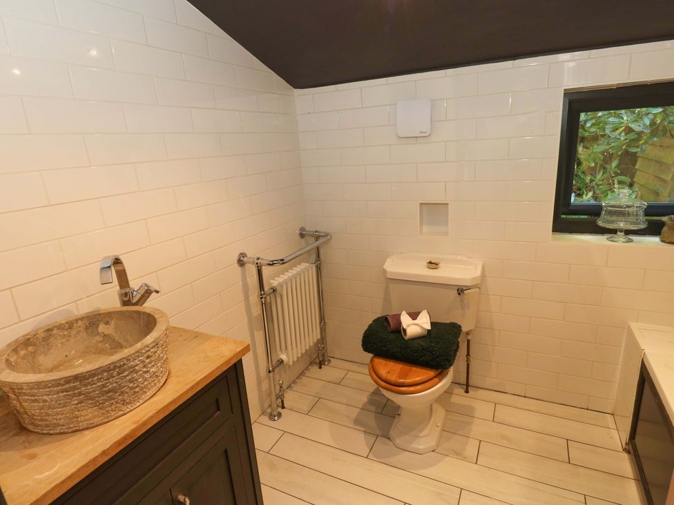 A bathroom with a toilet, sink, and radiator at Rocks Cottage in Halifax