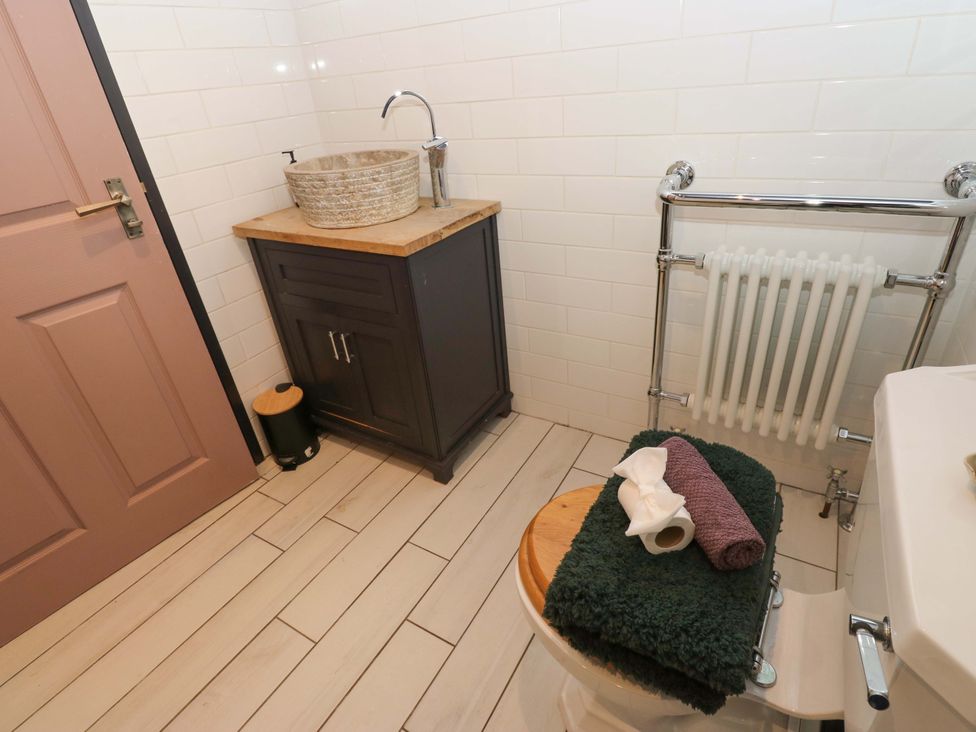 A bathroom with a sink, toilet, and vanity cabinet at Rocks Cottage Halifax