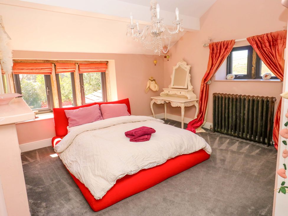 A bedroom with a bed, mirror, and windows at Rocks Cottage in Halifax
