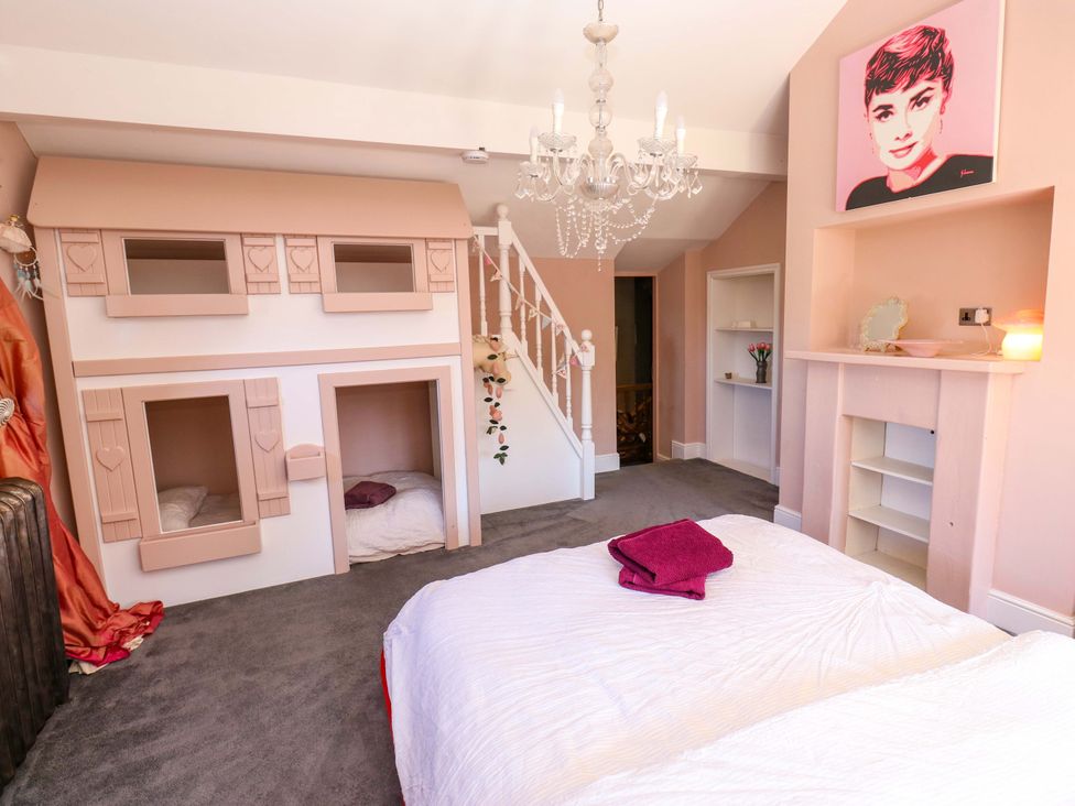 A bedroom with a chandelier and children's beds at Rocks Cottage Halifax
