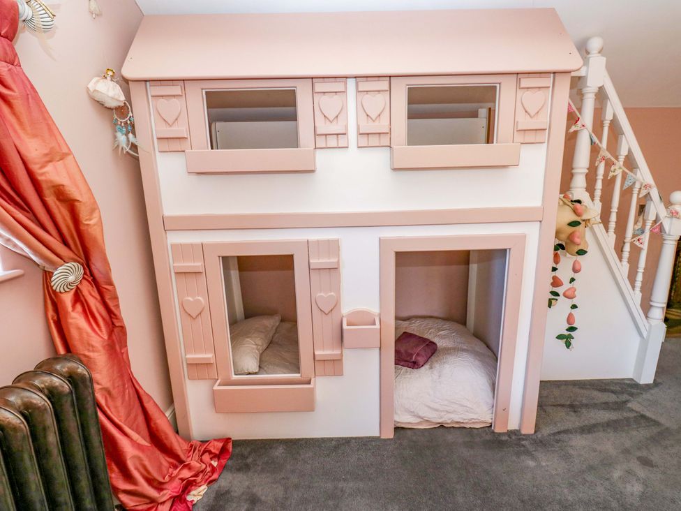A dollhouse with bedding in a children's play area at Rocks Cottage Halifax