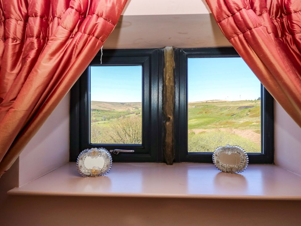 A window with curtains and decorative mirrors at Rocks Cottage in Halifax