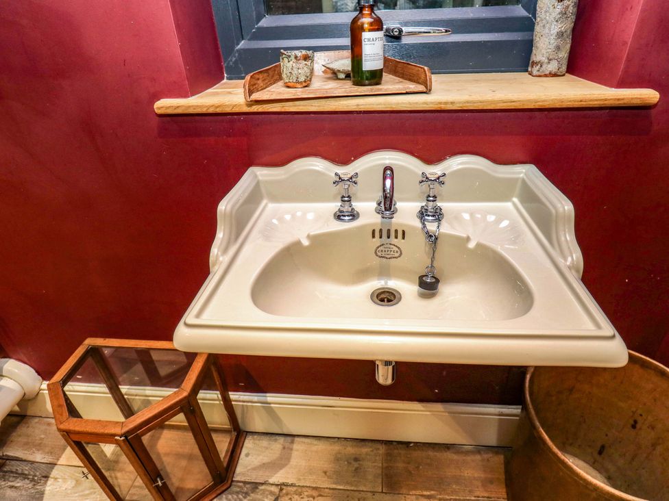 A sink with faucets and a window at Rocks Cottage in Halifax