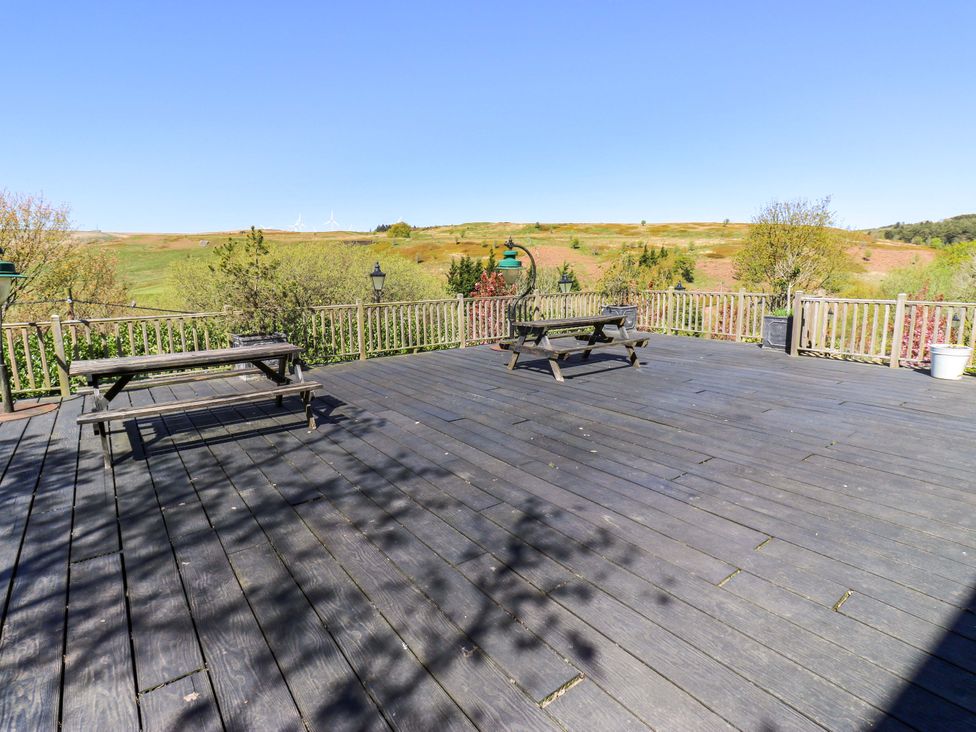 An outdoor deck with benches and park lamps at Rocks Cottage Halifax