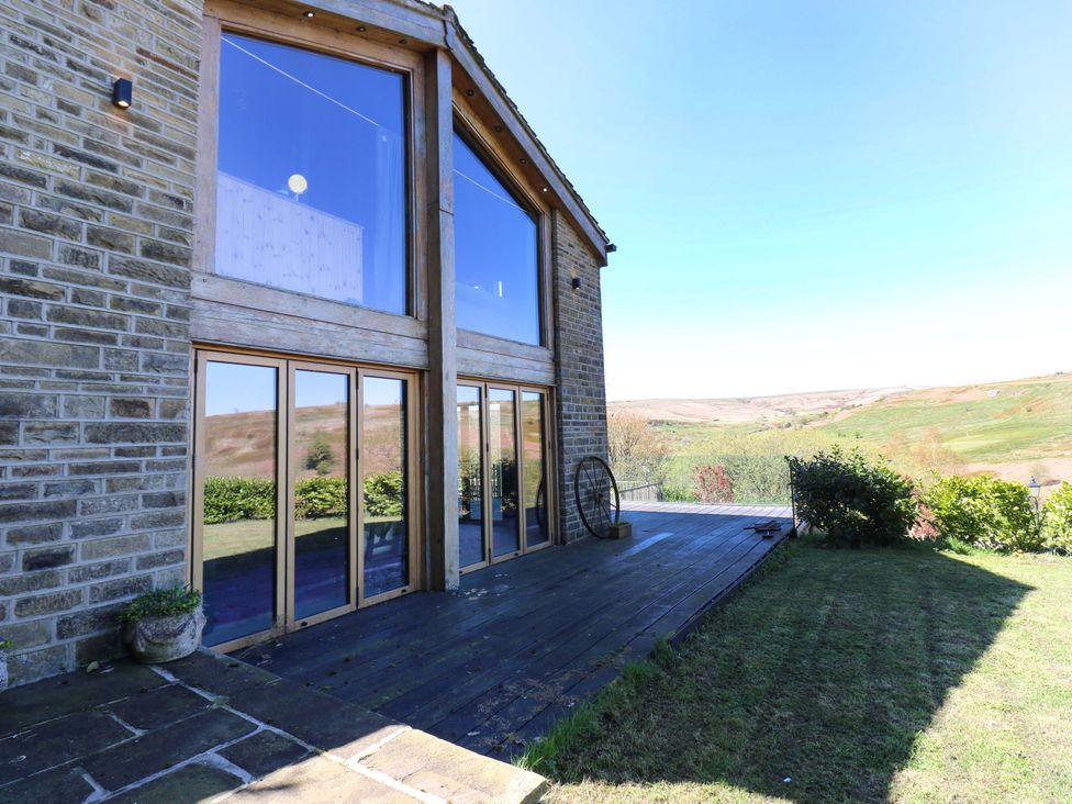 A patio area with large windows and green landscape at Rocks Cottage Halifax