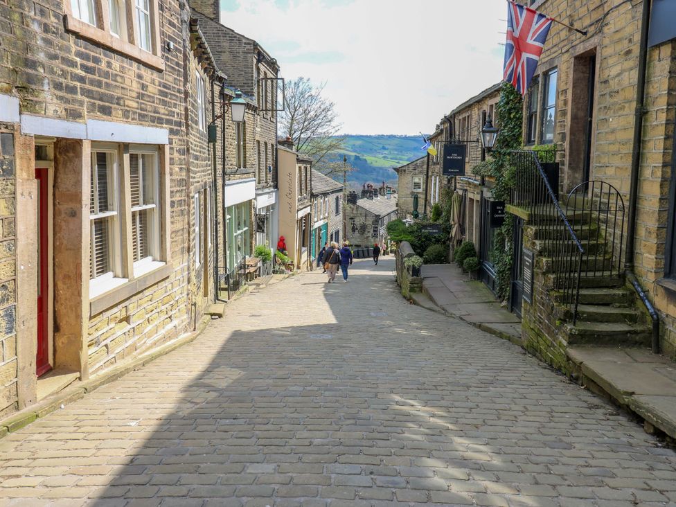 A stone street with brick buildings and people walking at Rocks Cottage in Halifax