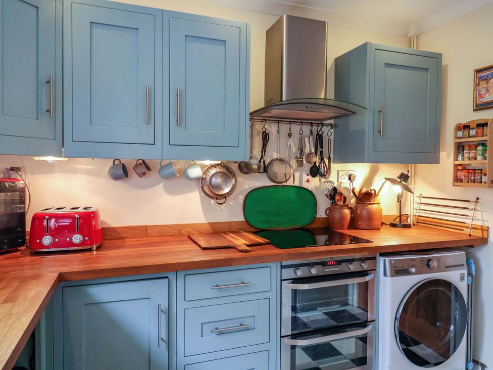 A kitchen with cabinets, a toaster, and a washing machine at 17 Demesne Gardens, Ipswich