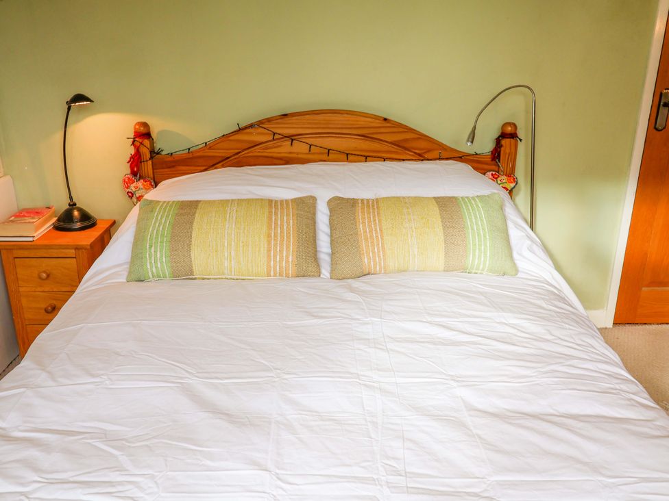 A bed with pillows and a lamp at 17 Demesne Gardens in Ipswich