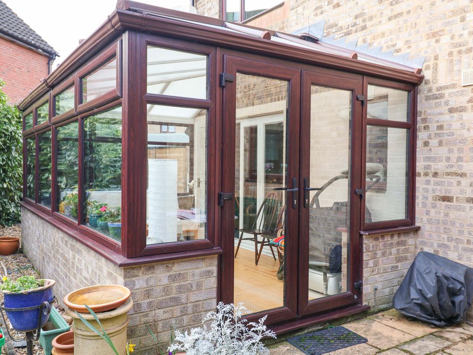 A conservatory with glass walls and wooden doors at 17 Demesne Gardens in Ipswich