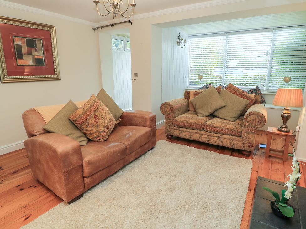 A living room with a sofa and armchair at Bosun's Deck in Christchurch