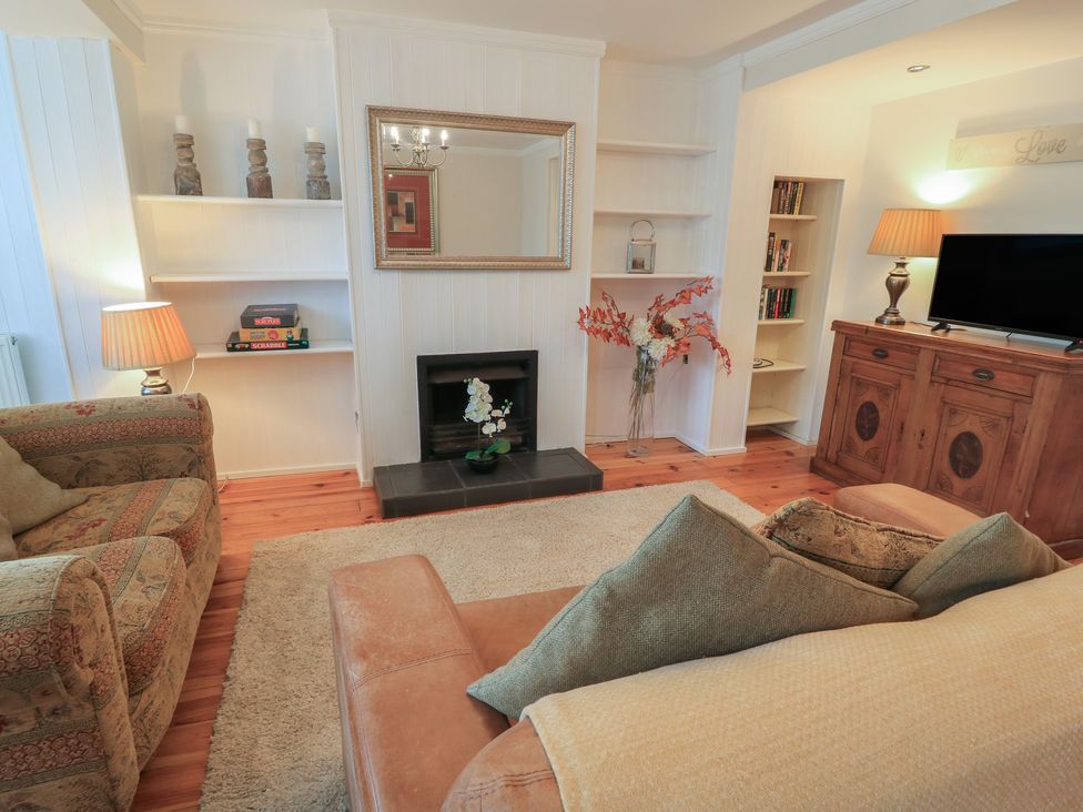 A living room with a fireplace and bookshelves at Bosun's Deck in Christchurch
