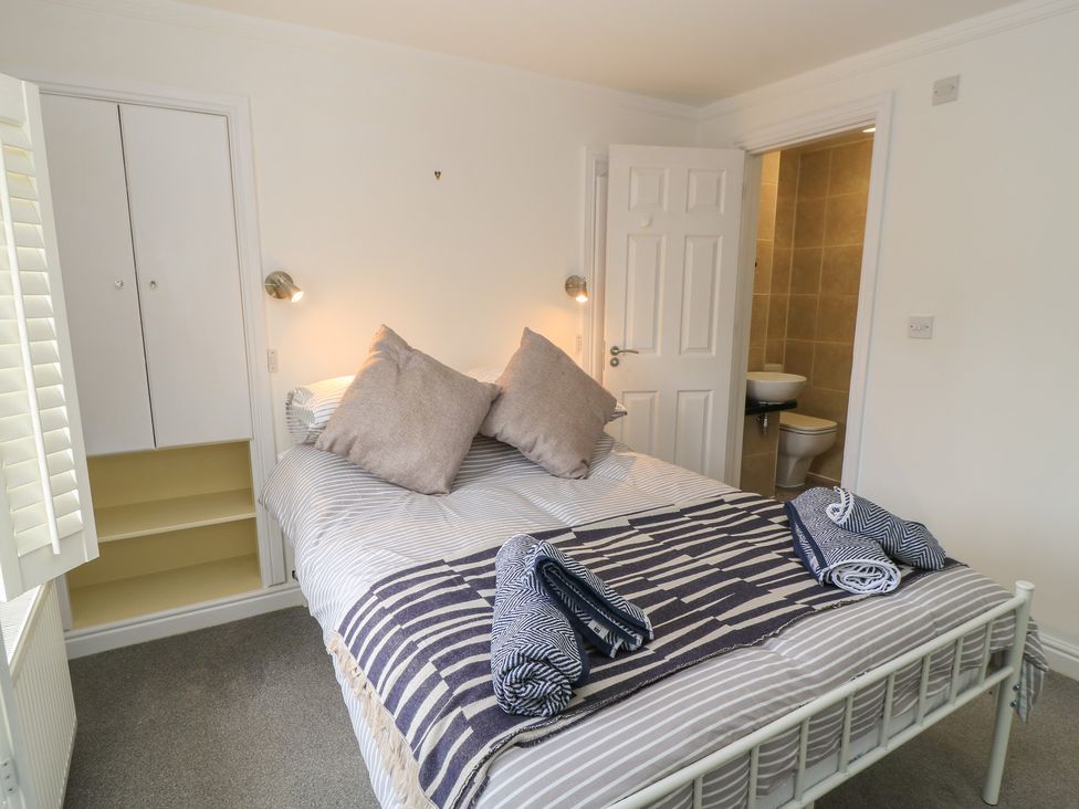 A bedroom with a bed and wardrobe at Bosun's Deck in Christchurch