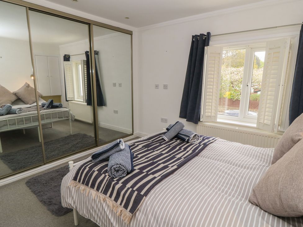 A bedroom with a bed and a mirror at Bosun's Deck in Christchurch