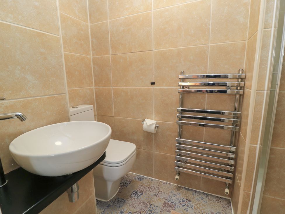 A bathroom with a sink, toilet, and towel rail at Bosun's Deck in Christchurch