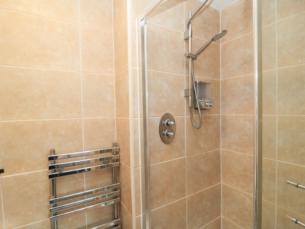 A shower with a showerhead and soap dispenser at Bosun's Deck in Christchurch