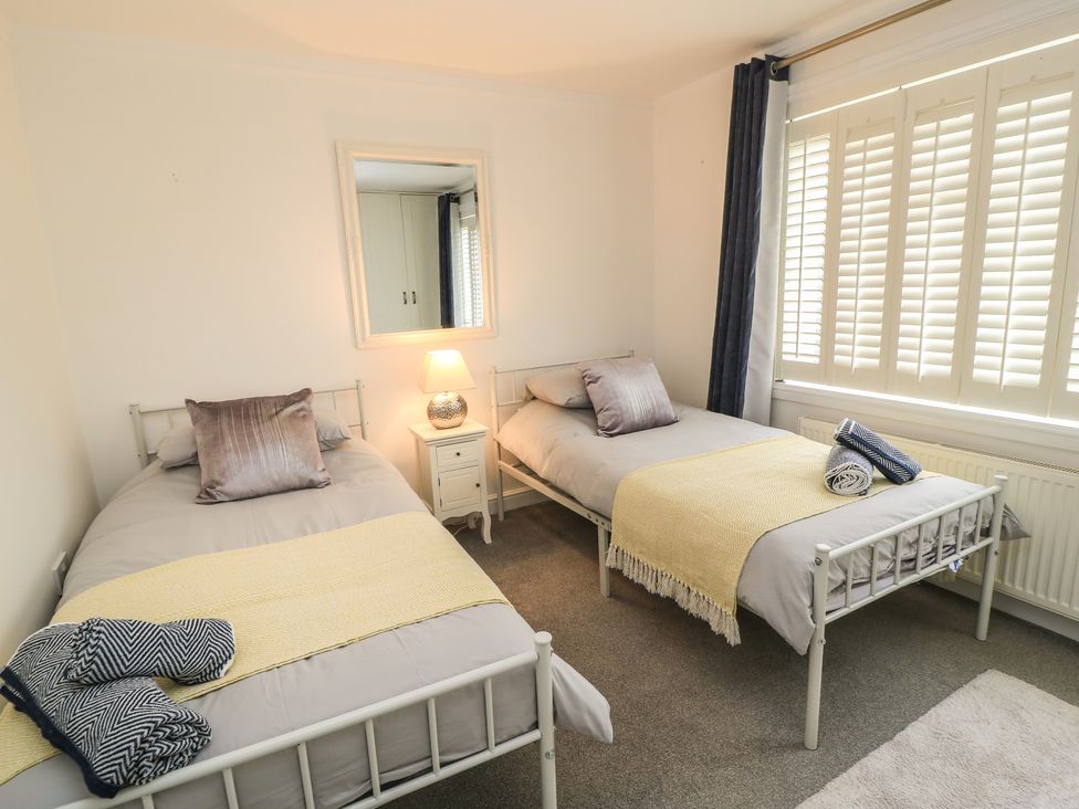 A bedroom with two beds and a lamp at Bosun's Deck in Christchurch