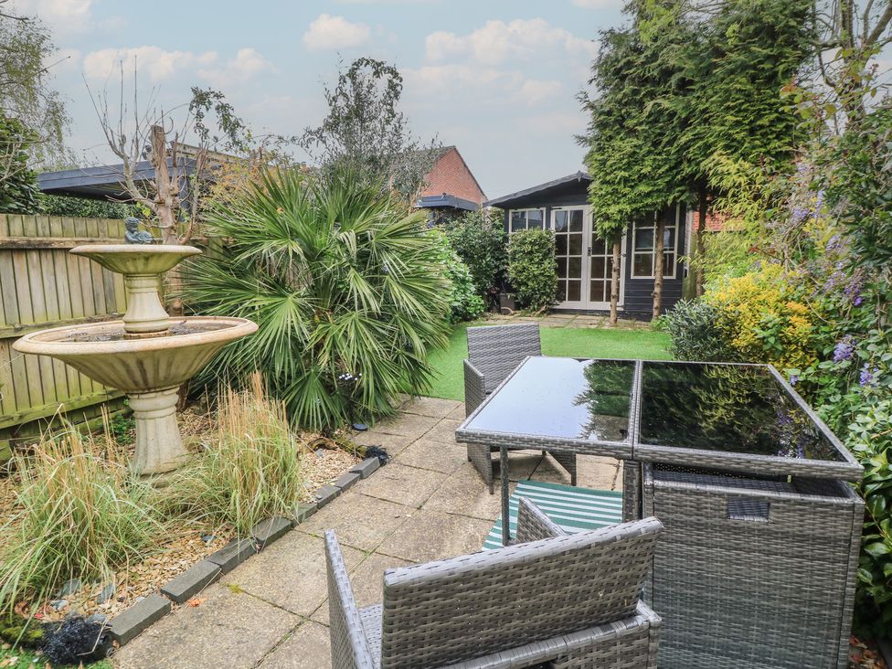 A garden with a fountain and outdoor furniture at Bosun's Deck in Christchurch