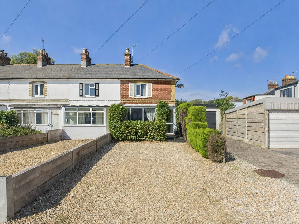 A house with a gravel yard and hedge at Bosun's Deck in Christchurch