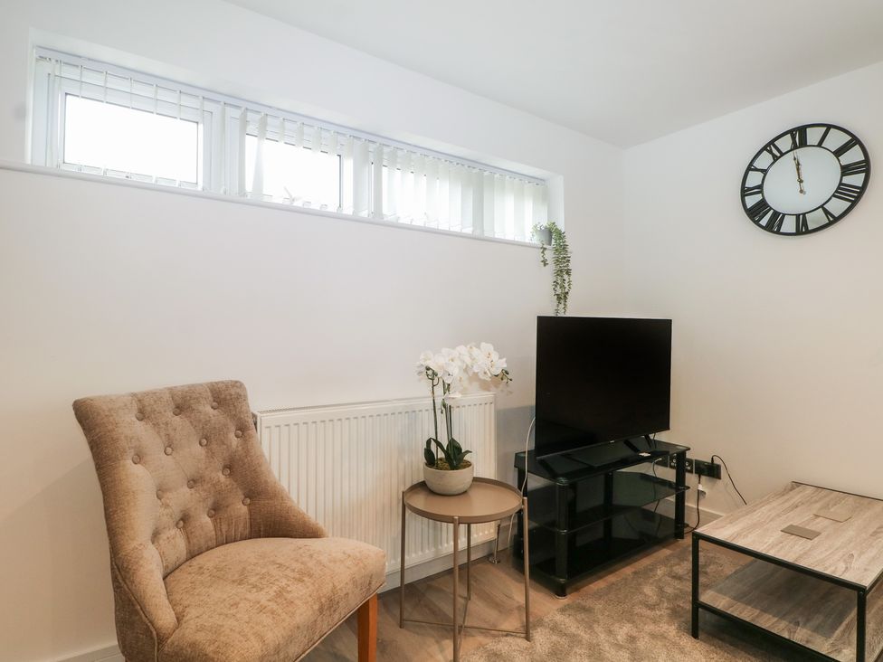 A living room with a television and a chair at The Annex in Slough