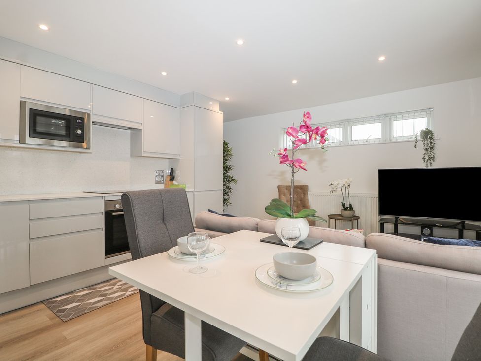 A kitchen area with dining table and sofa at The Annex in Slough