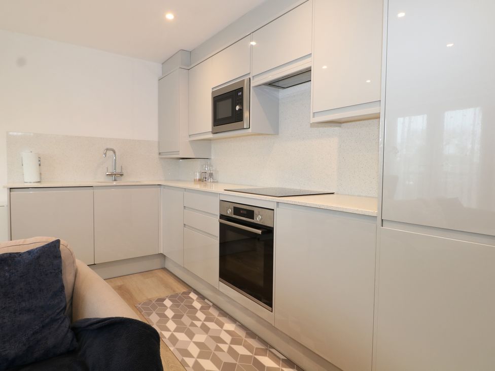 A kitchen with a sink, microwave, oven, and cooking hob at The Annex Slough