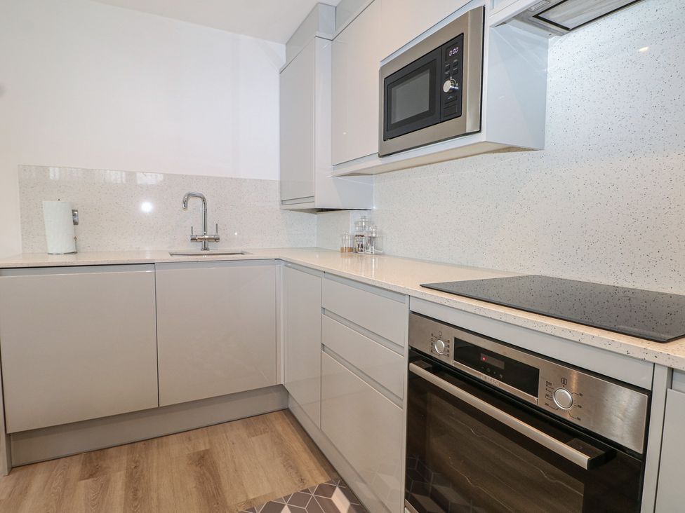 A kitchen with a sink, microwave, and oven at The Annex in Slough
