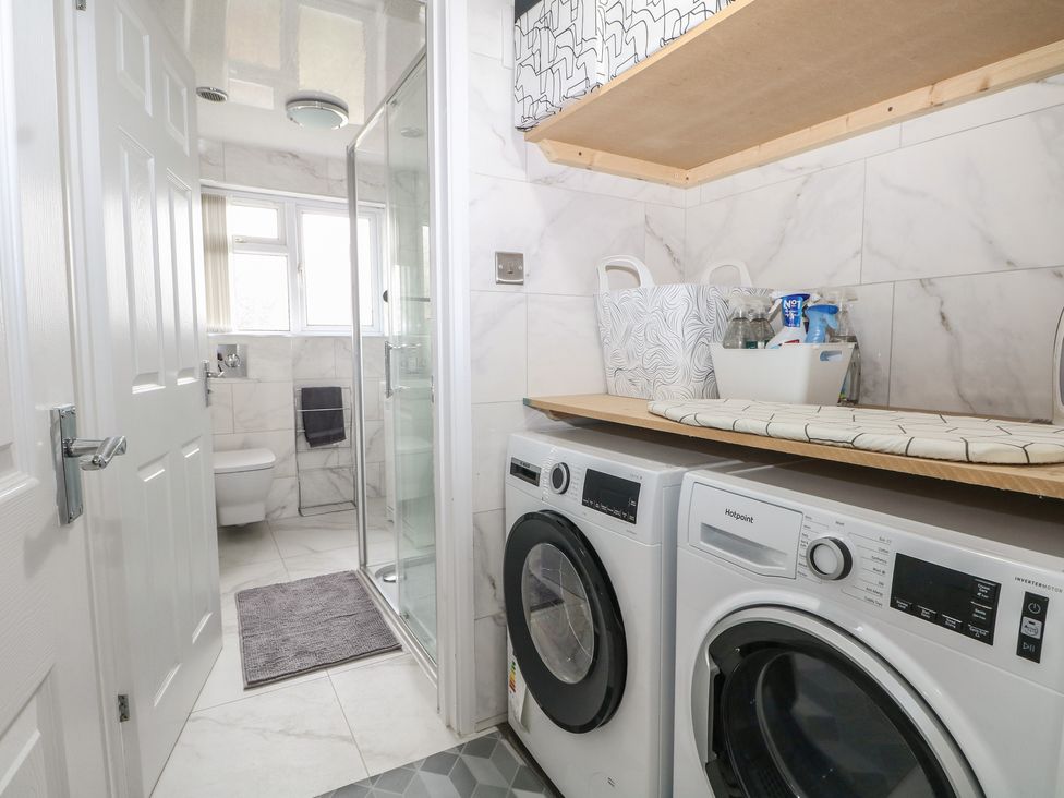 A laundry room with washing machine and tumble dryer at The Annex in Slough