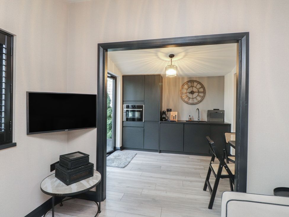 A kitchen with modern appliances and a television at Caban Tan Y Ffawydd Chwilog near Y Ffor