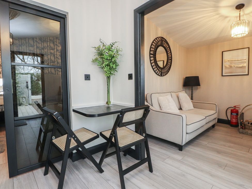 A living room with a sofa and a small table at Caban Tan Y Ffawydd in Chwilog near Y Ffor