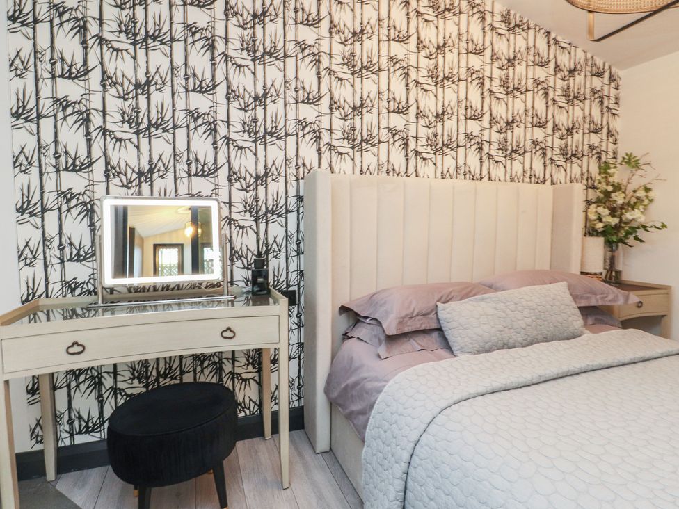 A bedroom with a bed and vanity table at Caban Tan Y Ffawydd in Chwilog near Y Ffor