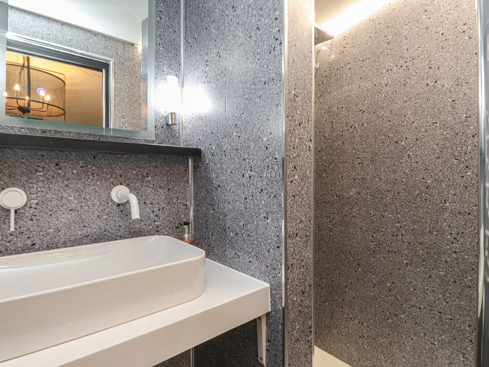 A bathroom with a sink and shower at Caban Tan Y Ffawydd in Chwilog near Y Ffor