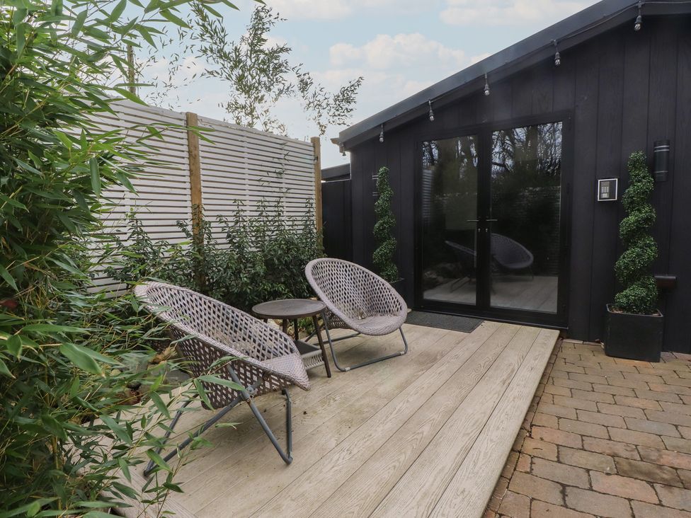 An outdoor space with chairs and table at Caban Tan Y Ffawydd near Chwilog