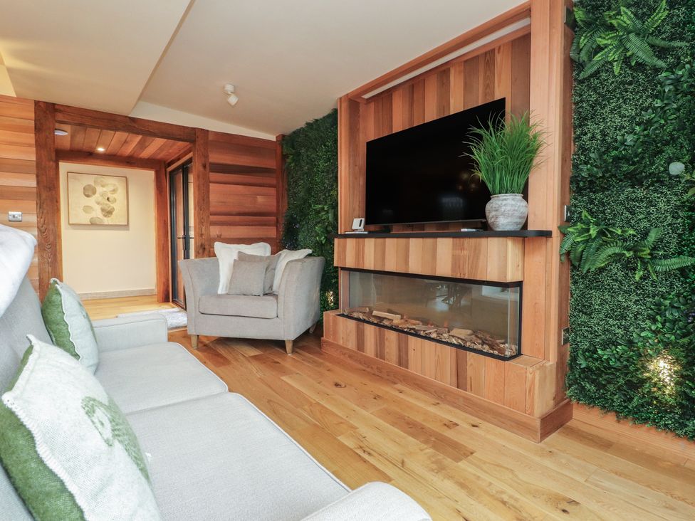 A living room with a sofa and armchair at Riverside Lodge in Afonwen