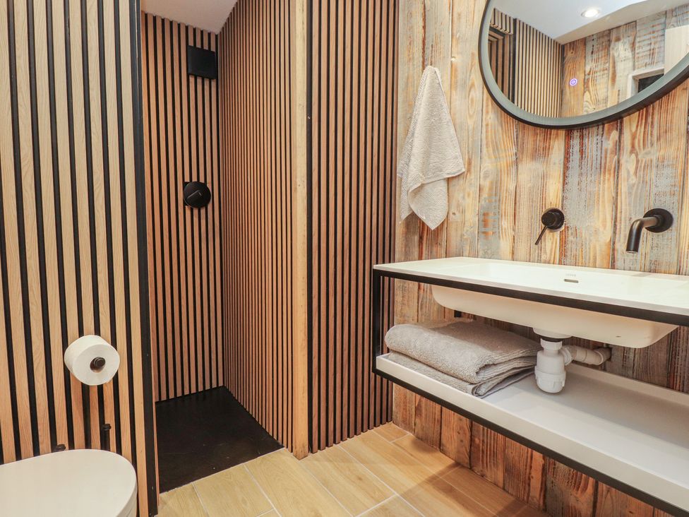 A bathroom with a sink, toilet, and shower at Riverside Lodge in Afonwen