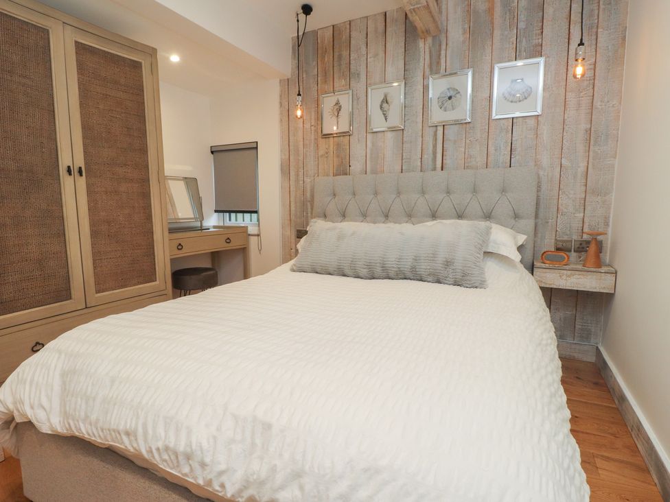 A bedroom with a bed and wardrobe at Riverside Lodge Afonwen